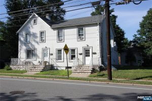 White two-family house on a corner lot