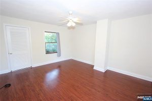 Bedroom with cherry floors and window