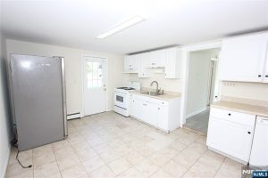 Kitchen with white cabinets and stainless refrigerator